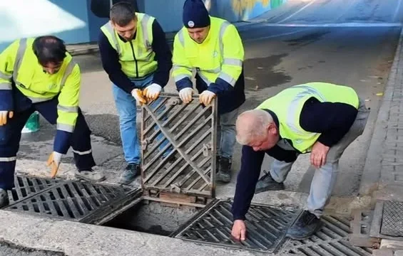 Yağmur suyu mazgal temizliği yapan ekipler, mazgalda biriken atıkları temizliyor.
