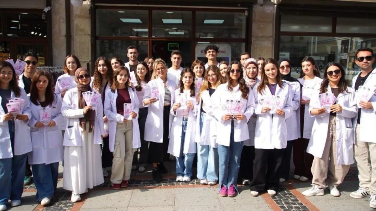 Edirne meme kanseri farkındalık etkinliğinde beyaz önlüklü öğrenciler Saraçlar Caddesi'nde vatandaşlara bilgi veriyor.